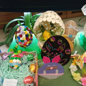 Stolik ze świątecznymi ozdobami. Modele jajek i świąteczne kartki wykonane przez dzieci