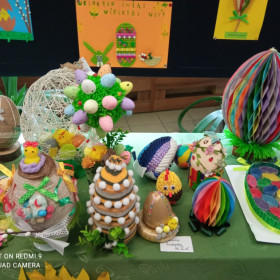 Stolik ze świątecznymi ozdobami. Modele jajek i świąteczne kartki wykonane przez dzieci