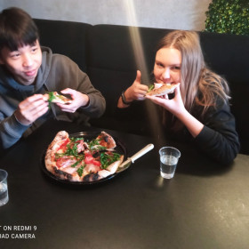 uczniowie jedzący zrobioną przez siebie pizzę w pizzerii "Głodna małpa"
